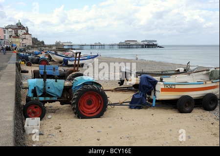 Ramponierte alte Traktoren ziehen die Fischerboote am Strand im Badeort von Cromer an der Küste von North Norfolk UK Stockfoto