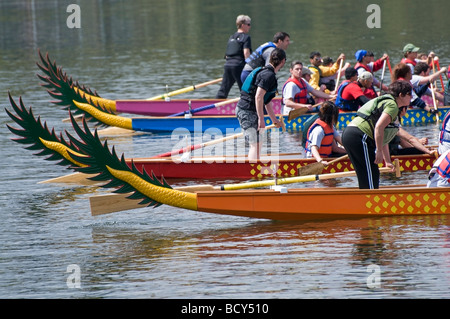 Seitenansicht von einer Reihe von Drachenbooten und ihre Athleten warten auf den Startschuss für den Beginn des Rennens zurück. Stockfoto