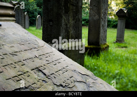 jüdischer Friedhof, Essen-Kettwig, Deutschland, geneigte Grabstein mit hebräischer Inschrift im Vordergrund aufgegeben Stockfoto