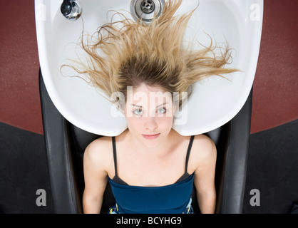 Frau am Waschbecken bei Friseuren Stockfoto