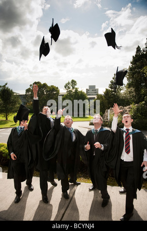 5 fünf männlichen Aberystwyth University Studenten Abschlusstag werfen ihre Mützen in die Luft in der Feier Wales UK Stockfoto