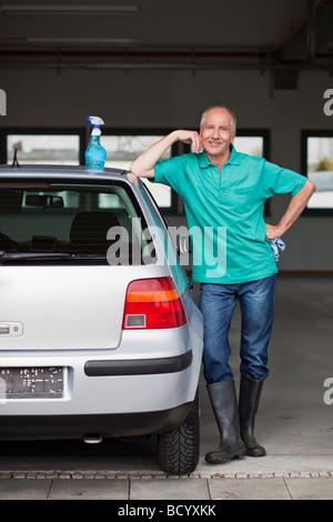 Alter Mann neben Auto mit Reinigungs-kit Stockfoto