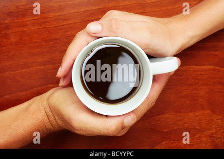 Kaffeetasse zwischen beiden Händen Yin und yang Stockfoto