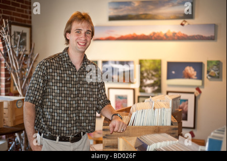 junges Unternehmen Galerist oder Arbeiter Lächeln auf den Lippen und in der Retail-Galerie zeigt die Ware zum Verkauf stehen Stockfoto