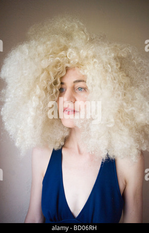 Porträt der 70er Jahre Frau mit wilden blonden lockigen Haaren Stockfoto