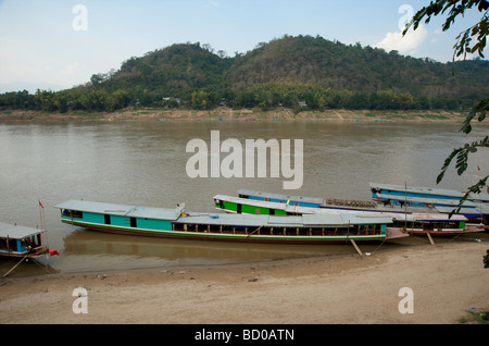 Hölzerne langsame Boote vertäut am Ufer des Mekong-Flusses in Luang Prabang Laos Stockfoto