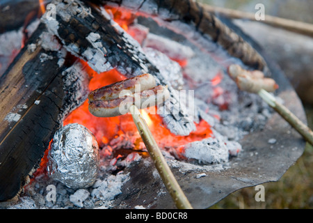 Würste Braten über Grill Feuer Stockfoto