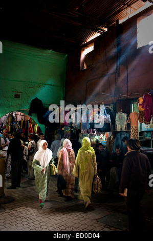 Arabische Frauen Einkaufen in eine alte Souk (Markt) in Marrakesch, Marokko, mit Sonnenlicht durch die Fenster Stockfoto