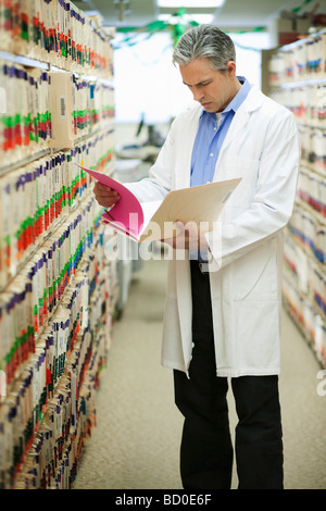 Männlichen Arzt lesen Krankenakte Stockfoto