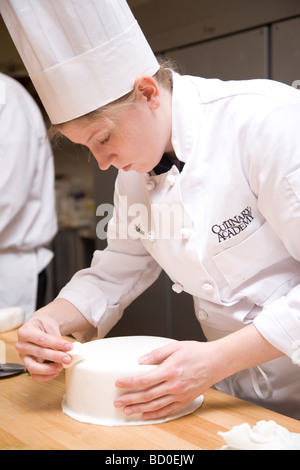 Frau Kuchen mit Fondant-Glasur vorbereiten. Stockfoto