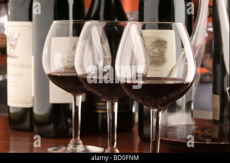 Drei rote Wein Gläser und Flaschen Stockfoto