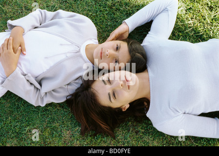 Mutter und Tochter zusammen liegende Gras, von direkt oben gesehen Stockfoto