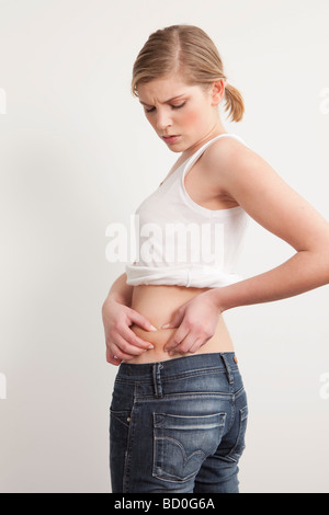 Frau Haut auf ihrem Bauch kneifen Stockfoto