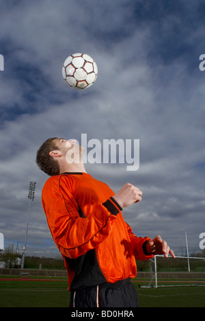 Fußballer, die einen Ball, um sich in Richtung Stockfoto