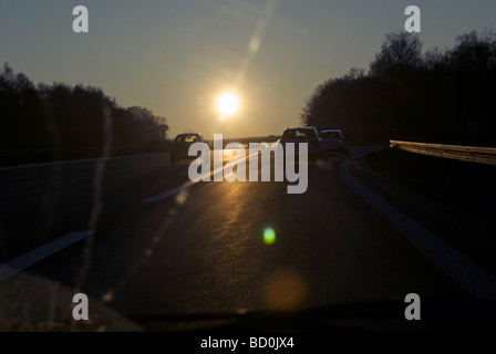 Fahren auf der Autobahn in einer untergehenden Wintersonne Stockfoto