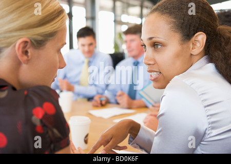 Geschäftsfrauen, die während der Sitzung miteinander zu reden Stockfoto