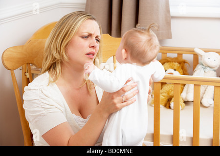 Betonte Mutter Holding Kind im Kindergarten Stockfoto