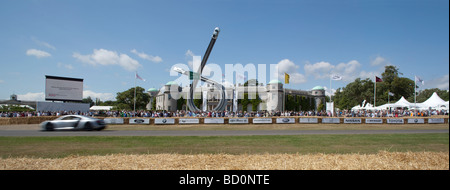 Audi Sportwagen in Bewegung auf dem richtigen Weg vor Goodwood House und Skulptur Stockfoto