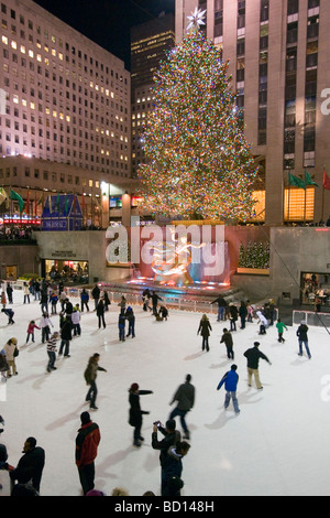 Schlittschuhläufer auf der Eisbahn am Weihnachtsbaum am Rockefeller Center in der Nacht. Stockfoto