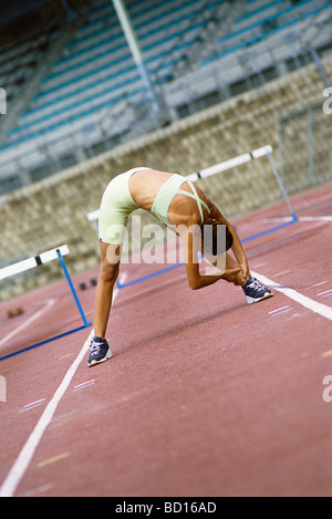 Frau tut erstreckt sich auf Laufband Stockfoto