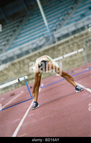 Frau tut erstreckt sich auf Laufband Stockfoto