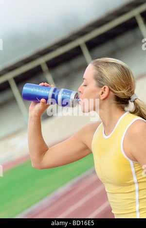 Sportliche Frau Trinkwasser aus der Flasche Stockfoto
