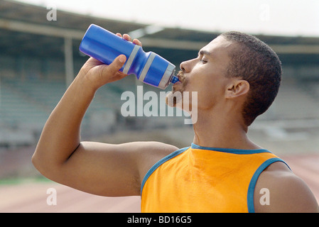 Sportlicher Mann Trinkwasser aus der Flasche Stockfoto