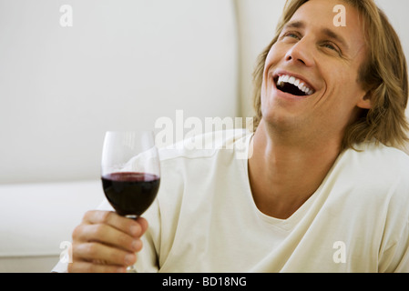 Mann hält Glas Rotwein, lachen Stockfoto