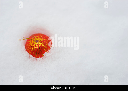 Christbaumkugel, die Hälfte im Schnee, erhöhte Ansicht begraben Stockfoto