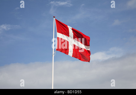 Die dänische Flagge Dannebrog gegen weiße Wolken und blauer Himmel. Stockfoto