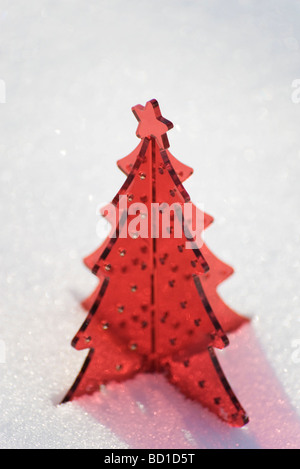 Roter Kunststoff Weihnachtsbaum Dekoration inmitten von Schnee Stockfoto