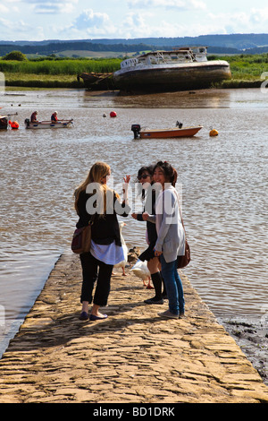 Eine attraktive Engländerin spricht mit zwei orientalische junge Frauen Besucher auf Topsham Riverfront Devon UK Stockfoto