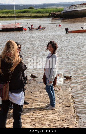Eine attraktive Engländerin nimmt ein Foto von zwei orientalische junge Frauen Besucher auf Topsham Riverfront Devon Uk Stockfoto