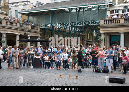 Menschen beobachten Entertainer in Covent Garden Piazza, London UK Stockfoto