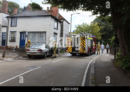 Feuerwehrleute aus Kent Feuerwehr und Rettungsdienst befassen sich mit einem Auto Feuer im Dorf Herne auf der A291 Kent UK Stockfoto