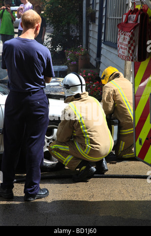 Feuerwehrleute aus Kent Feuerwehr und Rettungsdienst befassen sich mit einem Auto Feuer im Dorf Herne auf der A291 Kent UK Stockfoto