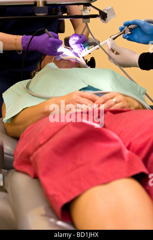Eine Patientin erhält eine Wurzelbehandlung von einer Zahnärztin. Stockfoto