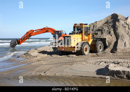 Navvy und Frontlader Graben und bewegt sich der sand in ein Schutzprojekt Küste. Stockfoto