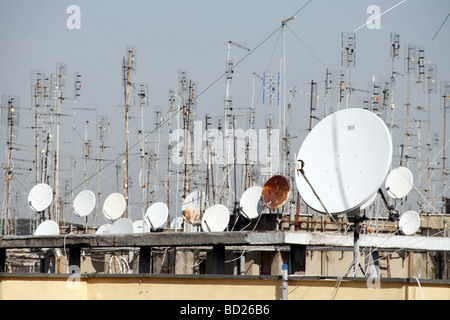 viele TV-Antennen und Satellitenschüsseln auf Dächern Stockfoto