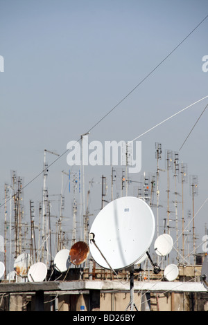 viele TV-Antennen und Satellitenschüsseln auf Dächern Stockfoto