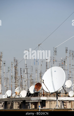 viele TV-Antennen und Satellitenschüsseln auf Dächern Stockfoto