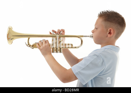 kleiner Junge bläst in eine Trompete vor weißem Hintergrund Stockfoto