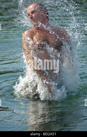 Ein Mann mittleren Alters ist unter Wasser, schneidigen. Das Wasser ist Sicke um ihn wegen seiner Dynamik. Stockfoto