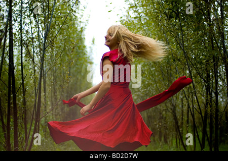 Junge Frau tanzt im Wald Stockfoto