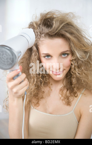 junge Frau trocknen Haare Stockfoto