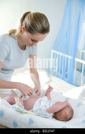 Mama, die Windel anziehen Stockfoto