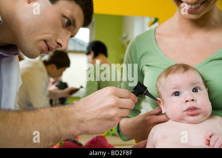 Arzt Untersuchung Kleinkind mit Otoskop Stockfoto