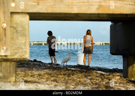 Menschen zu Fuß am Strand eingerahmt von Mole - Sanibel Island, Florida Stockfoto