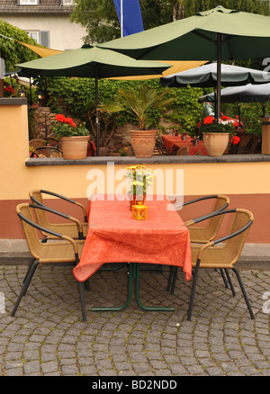 Leere Außenrestaurant Tabelle mit roten Tischdecke und vier Stühlen Aufnahme in Rüdesheim Deutschland Stockfoto