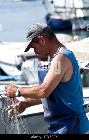 Fischer, die dazu neigt, seine Netze in der Marina Rovinj in Istrien Kroatien Stockfoto